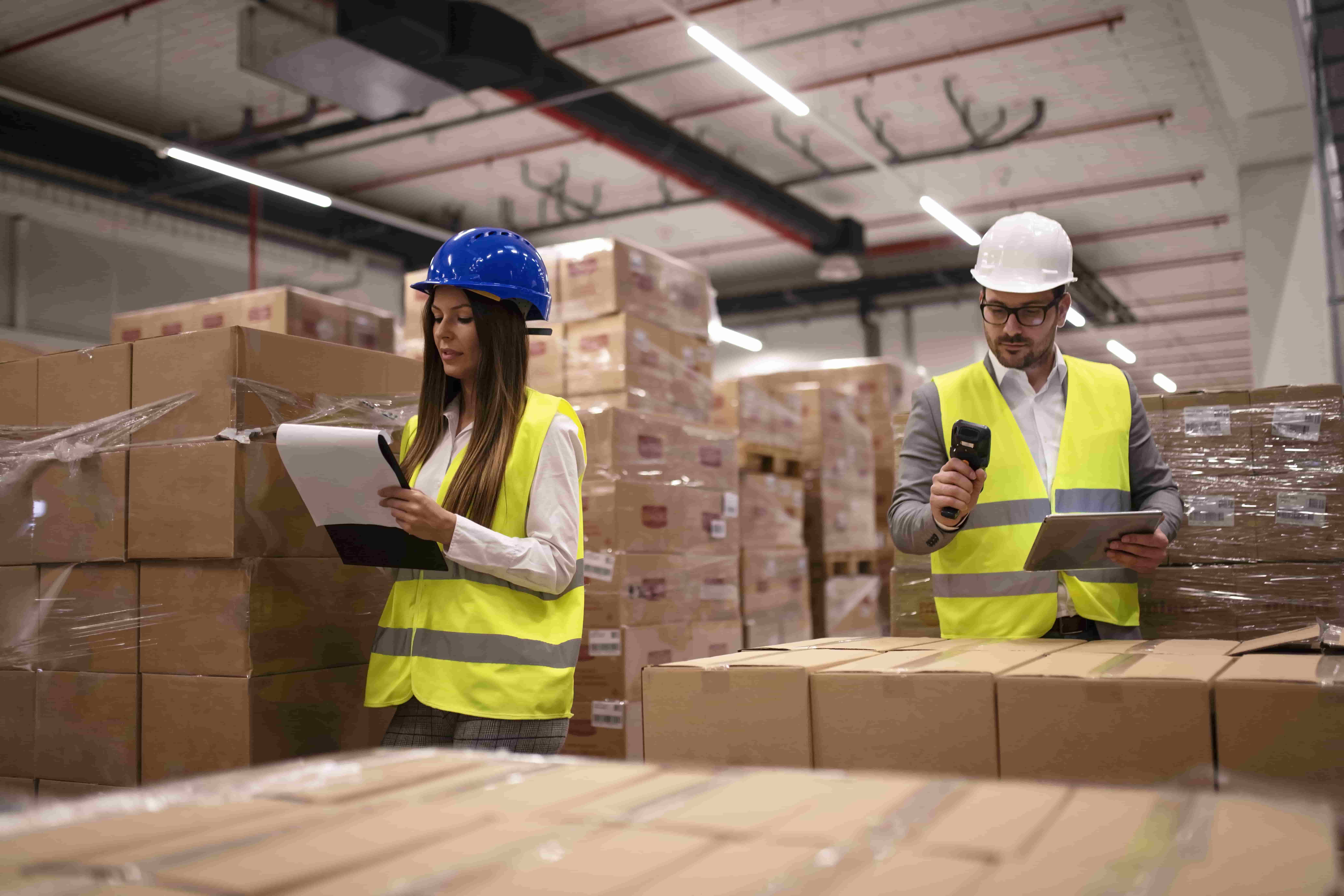 Una mujer y un hombre haciendo inventario de materia prima en un almacén